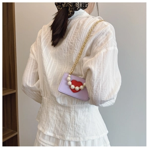 Vue détaillée du mini sac bandoulière mauve avec cœur rouge et anse en perles
