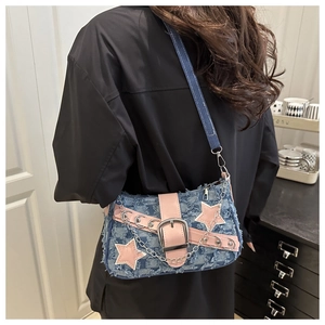 Detail of blue denim checkered shoulder bag with pink stars and silver chain