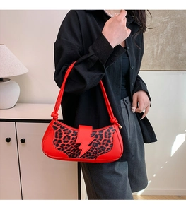 Détail du sac rouge à imprimé léopard avec rabat éclair et fines bretelles à nœuds