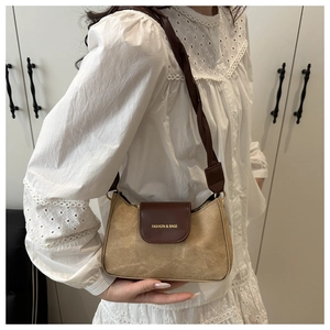 Detailed view of retro color-block underarm bag with woven strap and gold metal hooks