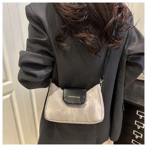 Rear view of a model wearing the grey and black contrast small square crossbody bag