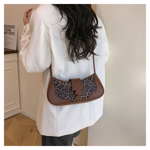 Detail of trendy leopard print baguette bag with unique brown lightning bolt decorative buckle