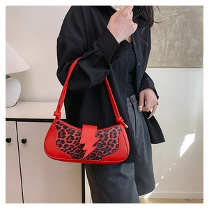 Detail of red PU leather bag with leopard print panel and stylish lightning buckle