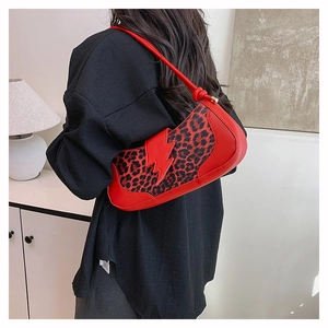Detail of red leopard print shoulder bag with lightning motif worn by model