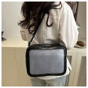 Vue détaillée du sac à bandoulière noir avec poche en maille grise porté par un modèle