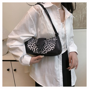 Détail du sac léopard avec boucle éclair noire et poignée nouée pour un style vintage