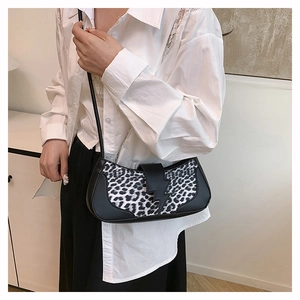 Détail du sac léopard avec boucle éclair unique porté à l'épaule par le mannequin