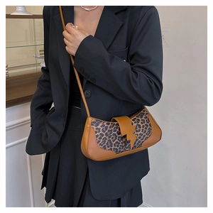 Détail du sac léopard avec boucle magnétique marron en forme d'éclair sur le rabat