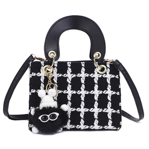 Borsa chic in tweed bianco e nero con manico, dettagli dorati e ciondolo furry