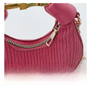 Détail de la fermeture éclair dorée et texture cuir rose plissée sur le sac à main