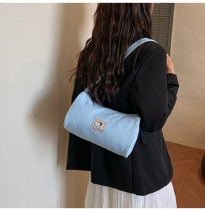 Detail of light blue canvas cylinder bag featuring a cute cartoon dog patch and texture