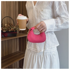 Gros plan du sac croissant rose plissé avec chaîne dorée et texture détaillée
