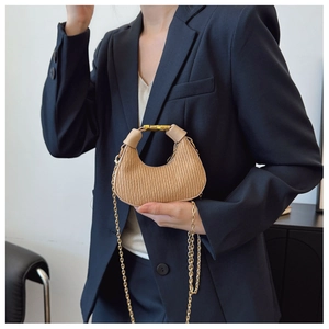 Détail du sac plissé kaki avec chaîne dorée et boucle métallique élégante au sac