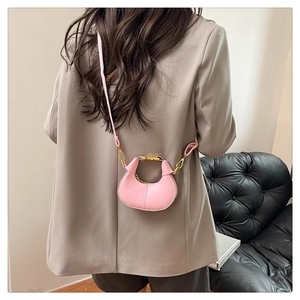 Vue détaillée d'un mini sac demi-lune rose avec coutures et boucle dorée élégante