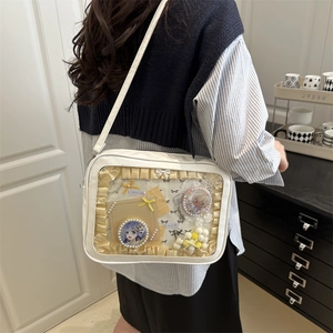 Minimalist white leather ita bag with clear window showing anime badges and ribbons
