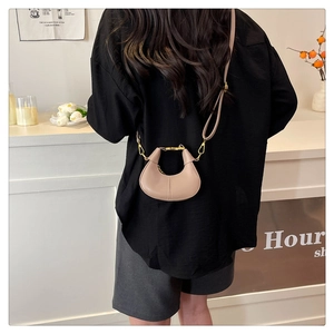 Detailed back view of a mini beige semi-circle crossbody bag with adjustable strap