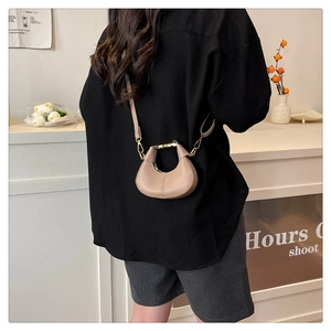 Détail d'un sac à bandoulière chic en cuir beige avec finitions métalliques dorées