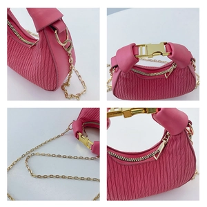 Détails du sac hobo matelassé rose avec boucle dorée et bandoulière chaîne sur fond blanc