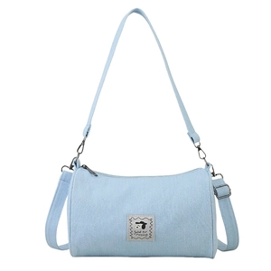 Light blue denim cylinder crossbody bag with cartoon dog patch and adjustable strap