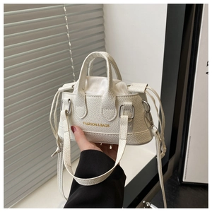 Close-up of white mini bucket bag featuring lychee texture and drawstring closure