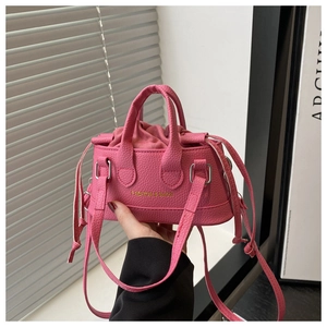 Detail of pink lychee leather mini bucket bag with drawstring closure and top handles