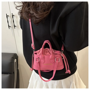 Pink mini crossbody bag featuring pebbled leather texture and interior drawstring pouch