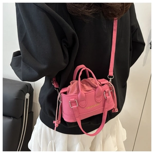 Pink mini bucket bag with drawstring closure and golden logo lettering on pebbled leather