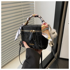Detail of black glossy box bag with silk scarf handle and plush monster charm