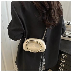 Chic beige crossbody bag with gold C-shaped metal clasp and thin chain strap detail