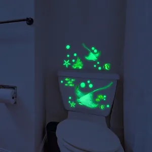 Luminous marine life wall stickers featuring glowing ocean fish and coral in a dark bathroom