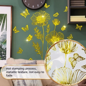 Macro detail of gold foil floral butterfly wall decals showing metallic mirror texture