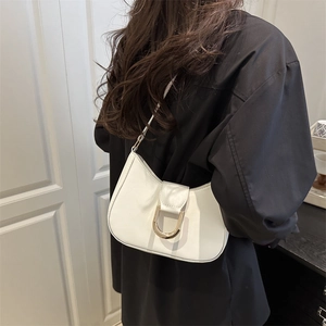 Minimalistische weiße Halbmond-Schultertasche aus Leder mit goldener Schnalle am Modell