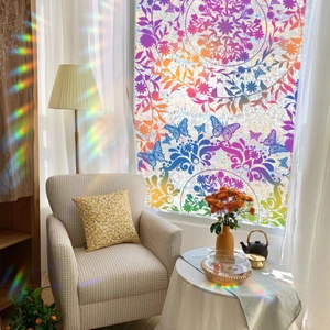 Colorful mandala and butterfly static window film creating rainbow light on a sofa