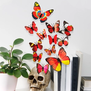 Detailed view of 3D red and yellow butterfly wall decals with vibrant patterns on a white wall
