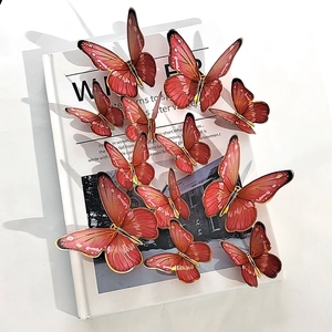 Detail of 3D orange and gold butterfly stickers on a book for wall decoration