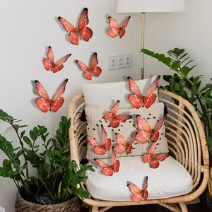 Detail of 3D coral red and gold butterfly wall stickers in a modern living room setup