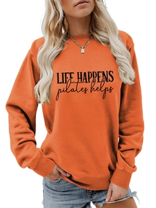 Detail of orange crewneck sweatshirt featuring Life Happens Pilates Helps text and ribbed cuffs