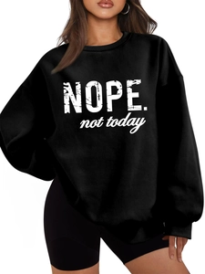 Close-up of 'NOPE. not today' white typography print on a black crewneck sweatshirt