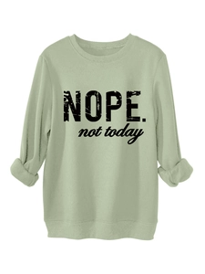 Detail of mint green sweatshirt featuring bold black NOPE not today slogan print