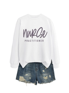 Flat lay of white Nurse Practitioner sweatshirt paired with distressed denim shorts
