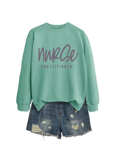 Detail of mint green sweatshirt with nurse practitioner print and denim shorts