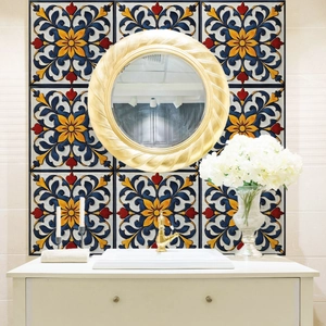 Detailaufnahme des goldenen Spiralrahmens vor farbenfrohen Boho-Fliesen im Badezimmer