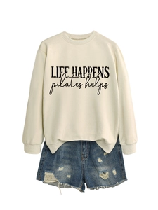 Detailed flat lay of cream crewneck sweatshirt with Life Happens Pilates Helps print