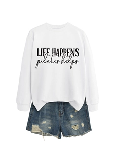 Flat lay of white sweatshirt with Life Happens print and distressed denim shorts