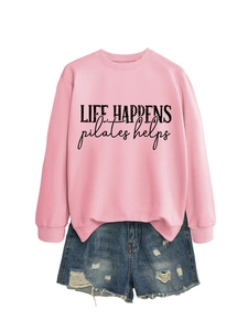 Detail of pink Life Happens Pilates sweatshirt paired with distressed blue denim shorts