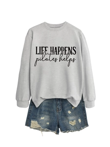 Detail of grey crewneck sweatshirt with Life Happens print and distressed denim shorts