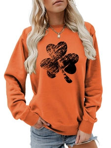 Detail of orange crewneck sweatshirt showing vintage shamrock print and ribbed cuffs