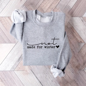 Detail of gray sweatshirt fabric and heart graphic with Not Made for Winter text