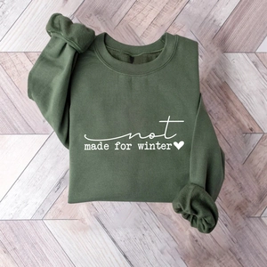 Detail view of slogan print on a forest green crewneck sweatshirt on wood background