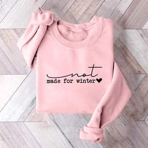 Flat lay detail of pink fleece sweatshirt with black Not Made For Winter print
